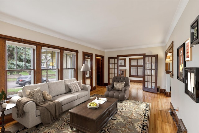 living room featuring crown molding, light hardwood / wood-style floors, and french doors