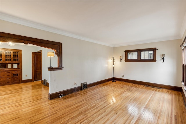 spare room with ornamental molding and light hardwood / wood-style floors