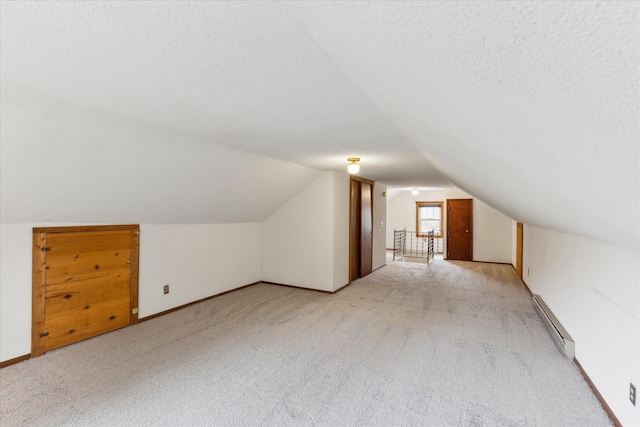 bonus room with light colored carpet, vaulted ceiling, a textured ceiling, and a baseboard radiator