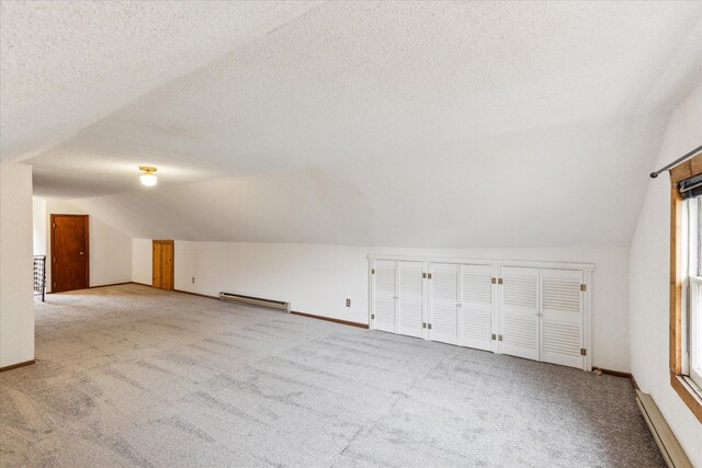 bonus room with light carpet, baseboard heating, vaulted ceiling, and a textured ceiling