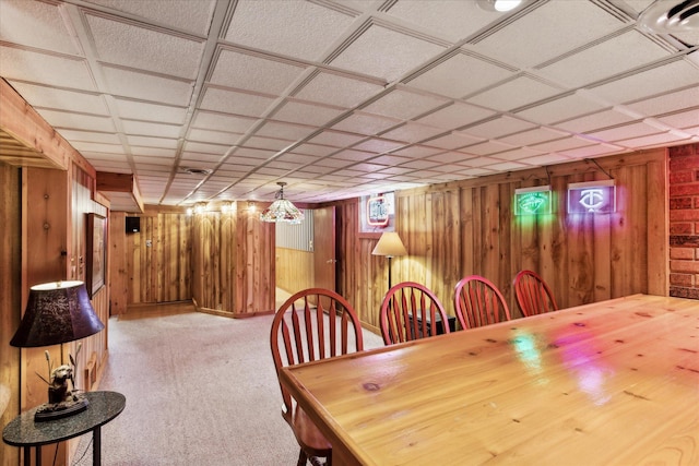 unfurnished dining area featuring light carpet and wooden walls