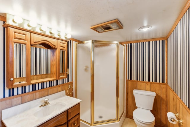 bathroom featuring vanity, toilet, and a shower with door