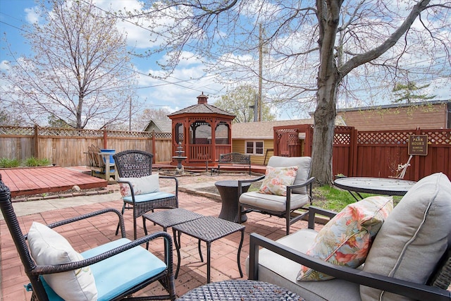 view of patio / terrace with a gazebo, a deck, and an outdoor living space