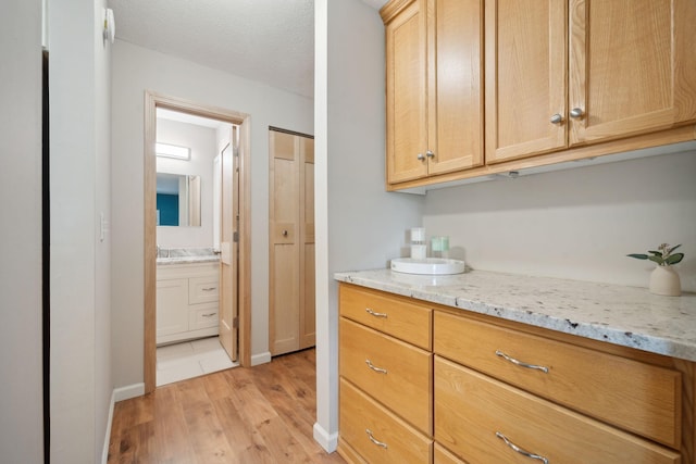 interior space featuring light hardwood / wood-style flooring, light brown cabinets, and light stone countertops