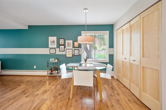 dining space featuring a baseboard radiator and light hardwood / wood-style floors