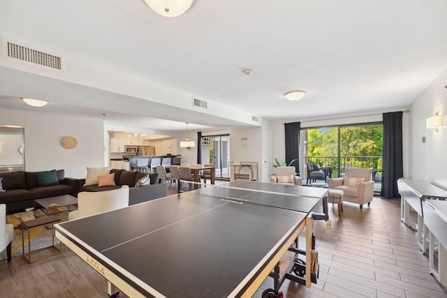 recreation room featuring a wall of windows and dark hardwood / wood-style floors