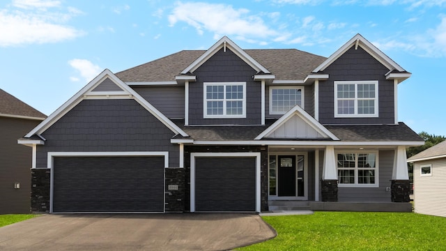 craftsman house with a front lawn and a garage