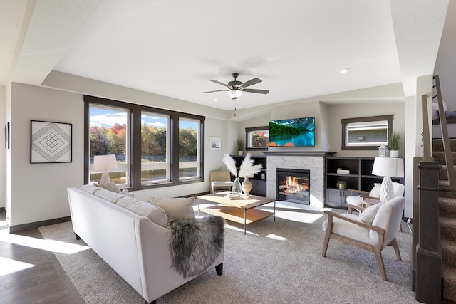 living room featuring a fireplace, wood-type flooring, and ceiling fan