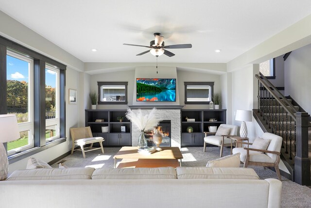 living room with ceiling fan, carpet, and a fireplace