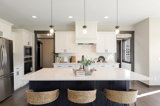 kitchen featuring a center island, decorative light fixtures, stainless steel appliances, and dark hardwood / wood-style floors