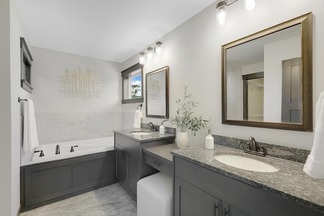 bathroom with a bathing tub, vanity, and tile patterned flooring