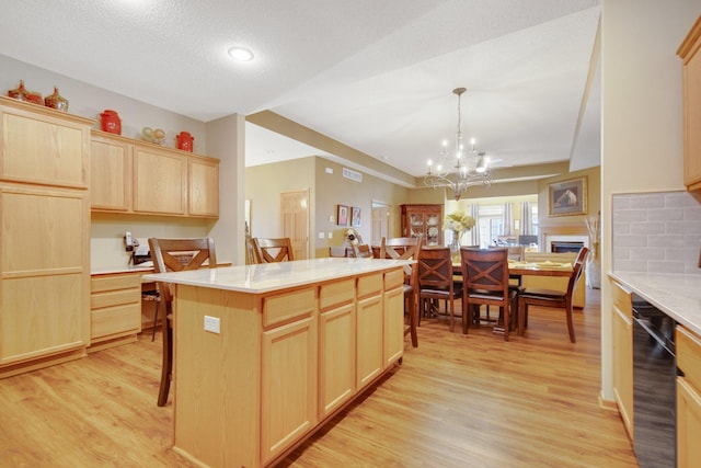 kitchen with pendant lighting, a center island, light wood-type flooring, and light brown cabinetry