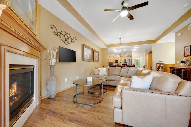 living room featuring hardwood / wood-style floors and ceiling fan with notable chandelier