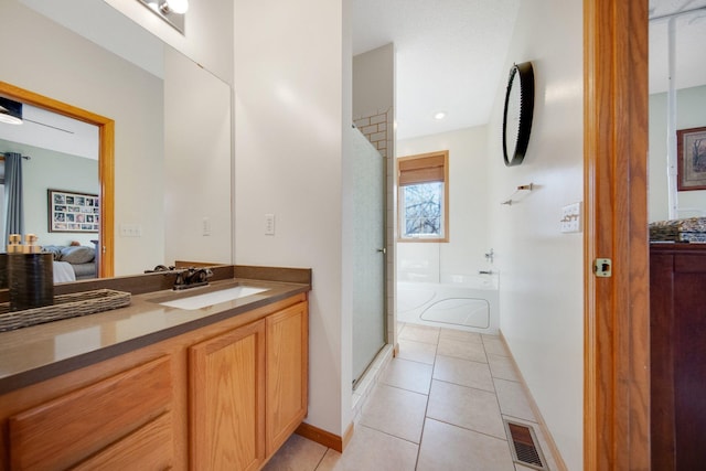 bathroom with tile patterned floors, separate shower and tub, and vanity