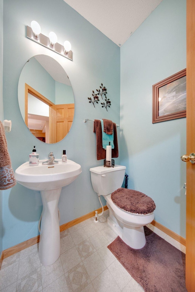 bathroom with toilet and a textured ceiling