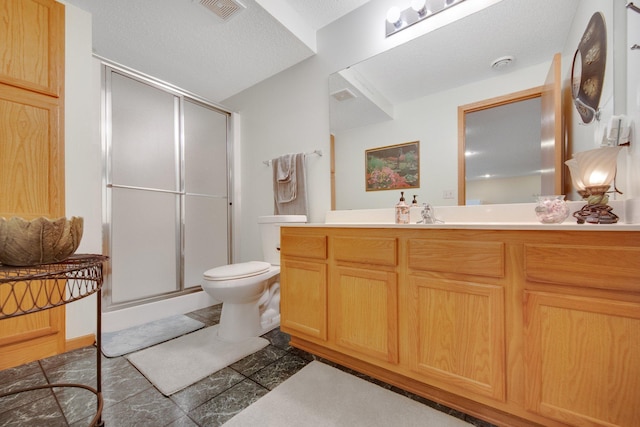 bathroom with vanity, toilet, and a shower with door