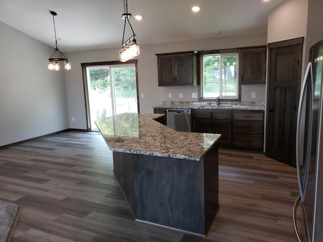 kitchen featuring decorative light fixtures, appliances with stainless steel finishes, dark hardwood / wood-style floors, a notable chandelier, and a center island