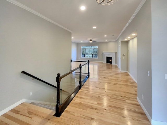 stairs featuring hardwood / wood-style flooring, ceiling fan, and ornamental molding