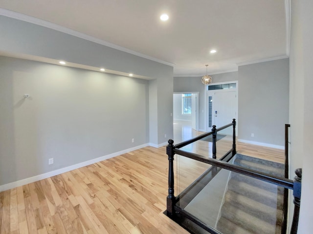 workout area featuring hardwood / wood-style flooring, an inviting chandelier, and crown molding