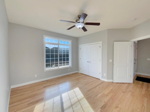 unfurnished bedroom with ceiling fan, a closet, and light hardwood / wood-style flooring