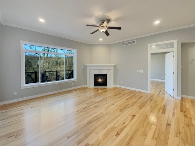 unfurnished living room with light hardwood / wood-style floors, ornamental molding, and a tile fireplace