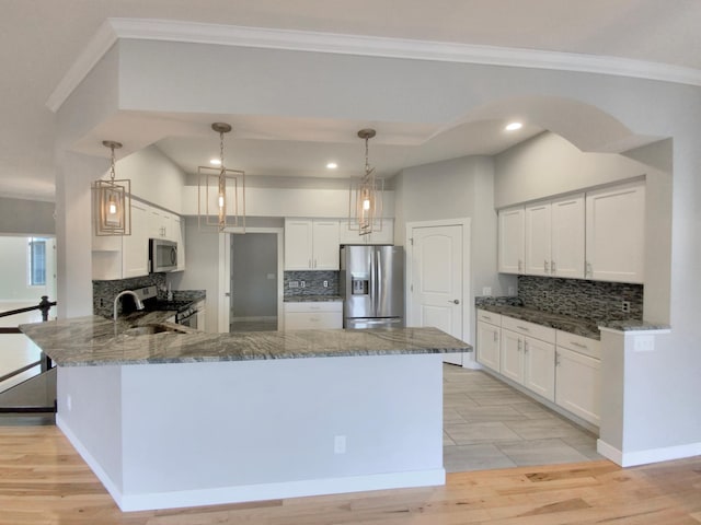 kitchen featuring white cabinets, decorative light fixtures, stainless steel appliances, and tasteful backsplash