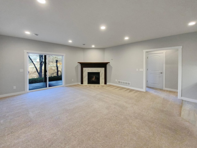 unfurnished living room featuring a fireplace and light colored carpet