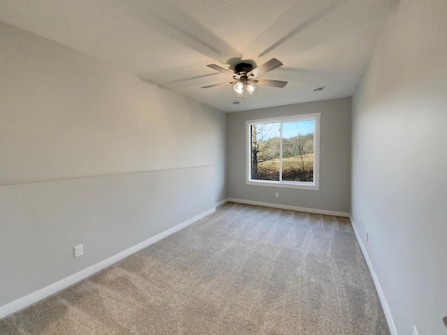 spare room featuring light carpet and ceiling fan