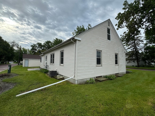 view of side of home featuring a lawn and central air condition unit