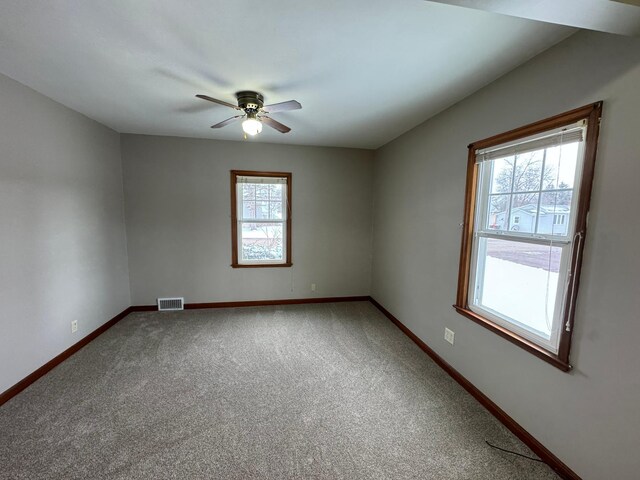 carpeted spare room with ceiling fan