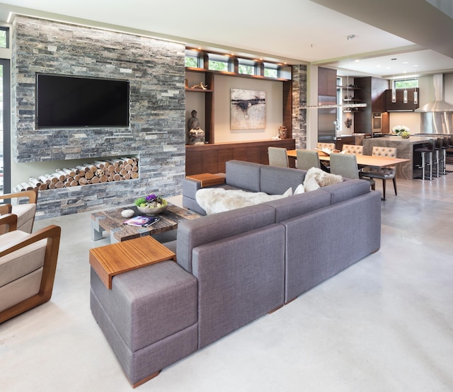 living area with concrete floors, a fireplace, and recessed lighting