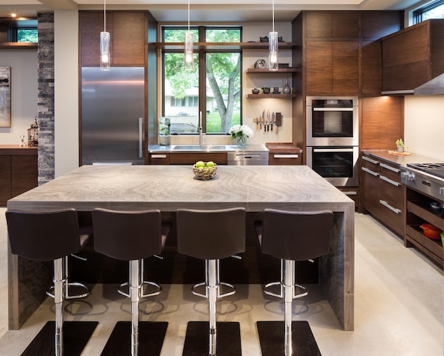 kitchen featuring stainless steel appliances, a kitchen island, a breakfast bar area, and open shelves