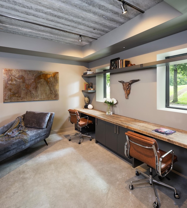 office featuring a wealth of natural light, built in desk, and track lighting