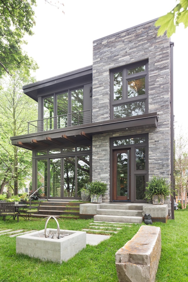 entrance to property featuring a balcony and a yard