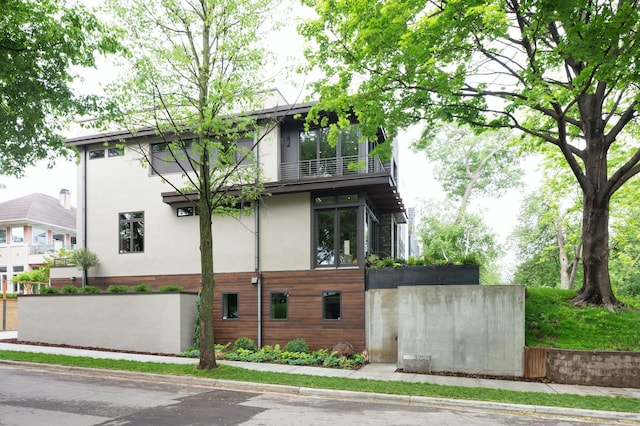 exterior space with a balcony and stucco siding