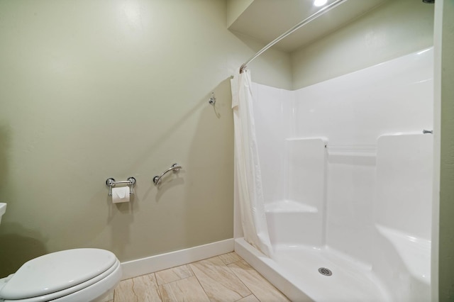 bathroom with curtained shower and toilet