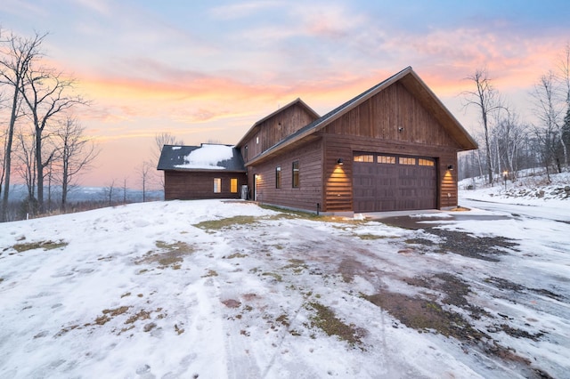 snow covered property with a garage