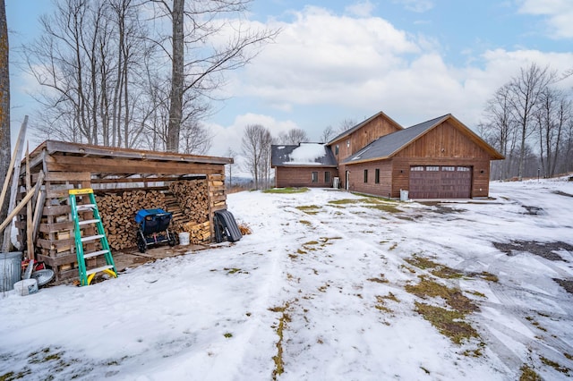 snowy yard featuring a garage