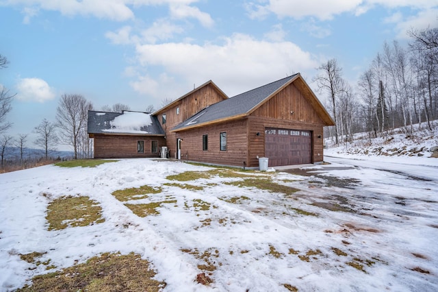 view of snow covered exterior featuring a garage