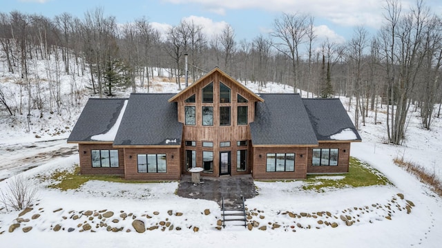 view of snow covered back of property