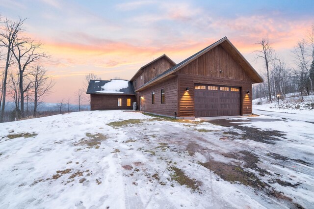 view of snowy exterior with a garage