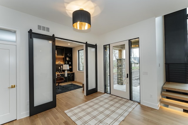 4163 Christopherson Ln SW, Rochester, MN 55902 - entryway featuring a barn door, light wood-style floors, and baseboards