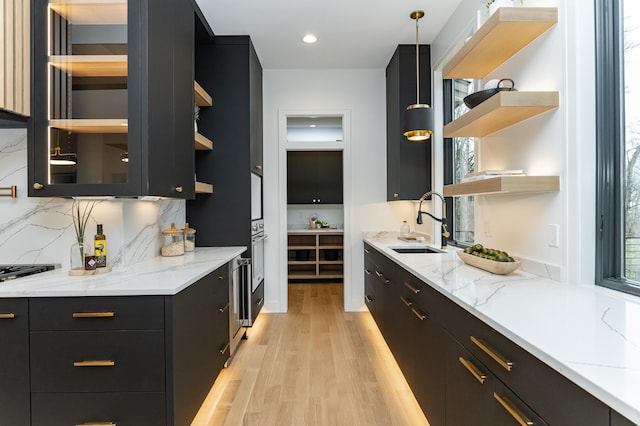 4163 Christopherson Ln SW, Rochester, MN 55902 - bar with a sink, light wood-style flooring, decorative light fixtures, backsplash, and oven