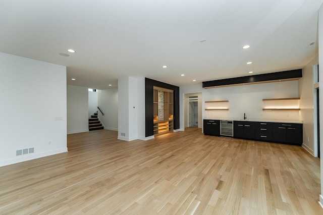 4163 Christopherson Ln SW, Rochester, MN 55902 - unfurnished living room with wet bar, stairs, wine cooler, recessed lighting, and light wood finished floors