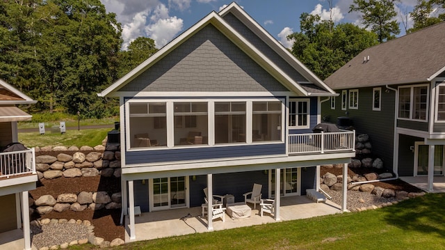 back of property featuring a yard, a sunroom, and a patio