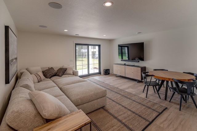 living room featuring light hardwood / wood-style flooring and a textured ceiling