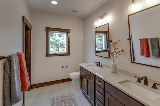 bathroom with double sink vanity, toilet, and tile floors