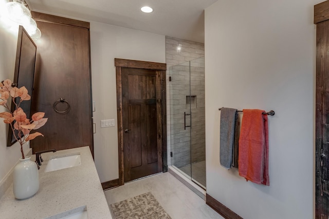 bathroom featuring a shower with door, tile flooring, and dual vanity