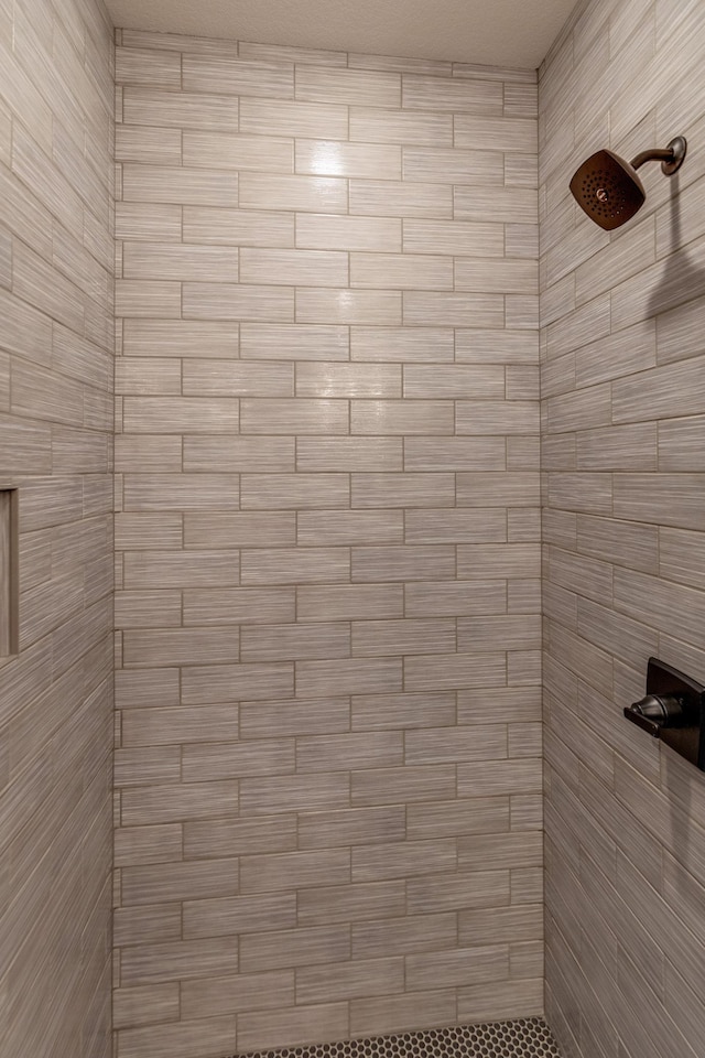 interior details with a tile shower