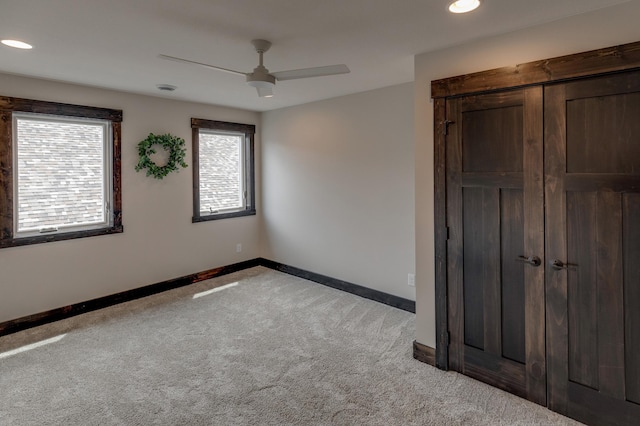 unfurnished bedroom with ceiling fan, light colored carpet, and a closet